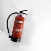 Red fire extinguisher on a white wall